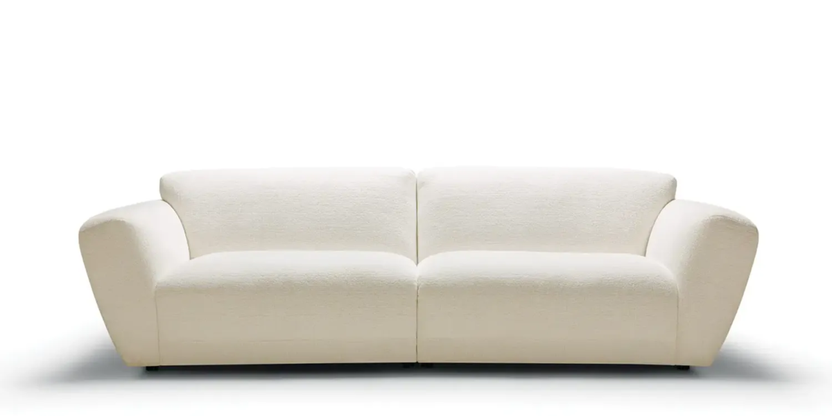Une photo du canapé Asta blanc dans un salon contemporain avec des murs gris clair et des accents de couleur vive pour une ambiance dynamique et moderne.