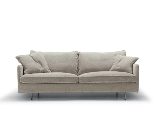 Canapé moderne gris clair avec quatre coussins et pieds en métal, photographié sur fond blanc. Canape Paris by Atelier Bis