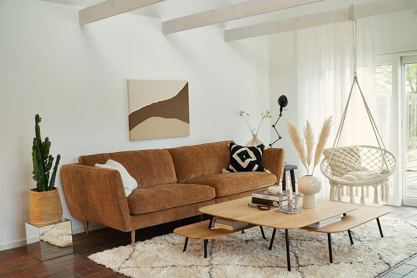 Salon moderne avec un canapé marron, une table basse en bois, une chaise suspendue, des plantes et un décor neutre. Canape Paris by Atelier Bis