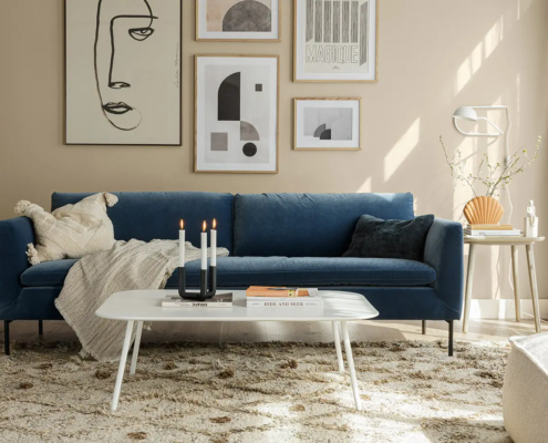 Salon moderne avec canapé bleu, art mural abstrait, table basse blanche et décor neutre. Canape Paris by Atelier Bis