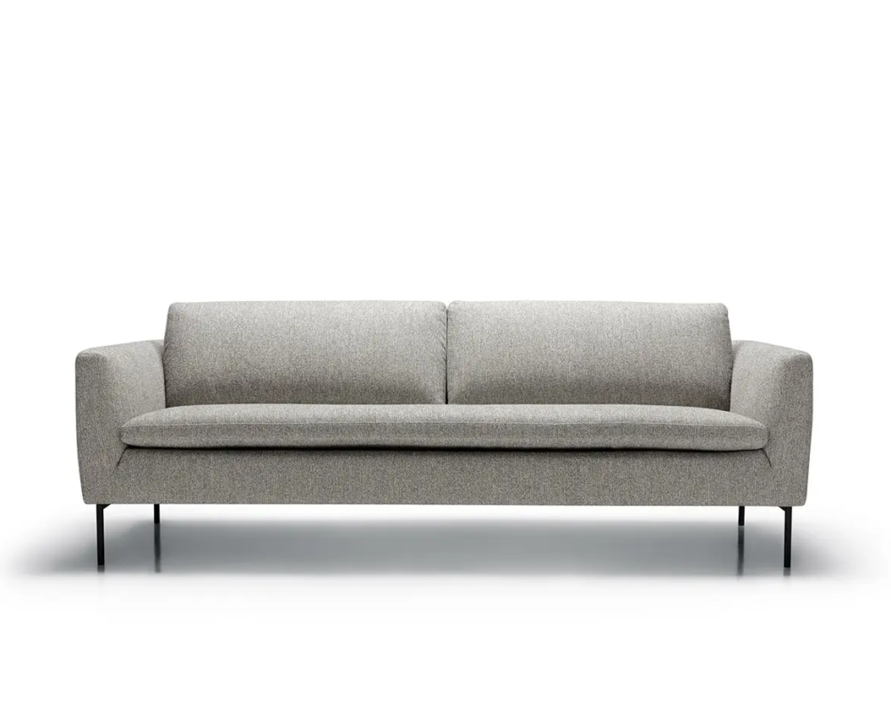 Canapé moderne gris avec de fins pieds noirs, vu de face sur fond blanc. Canape Paris by Atelier Bis