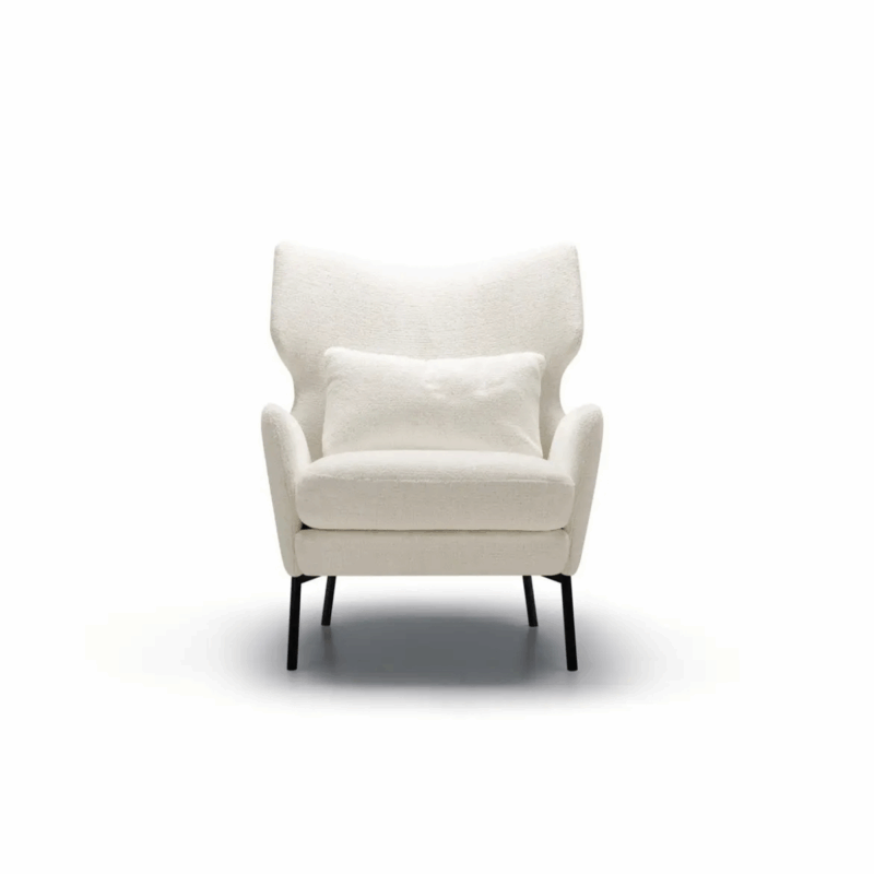 Fauteuil moderne blanc avec un coussin assorti, doté de pieds noirs, isolé sur fond blanc. Canape Paris by Atelier Bis
