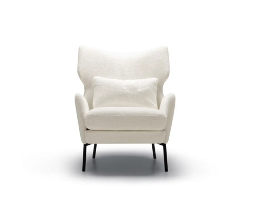 Fauteuil moderne blanc avec un coussin assorti, des pieds noirs et un dossier ailé, sur un fond uni. Canape Paris by Atelier Bis