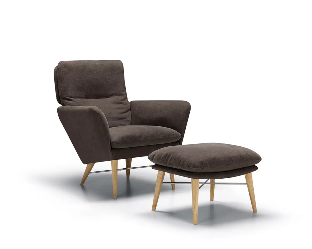 Fauteuil moderne marron foncé et ottoman assorti, tous deux avec des pieds en bois, sur fond blanc. Canape Paris by Atelier Bis