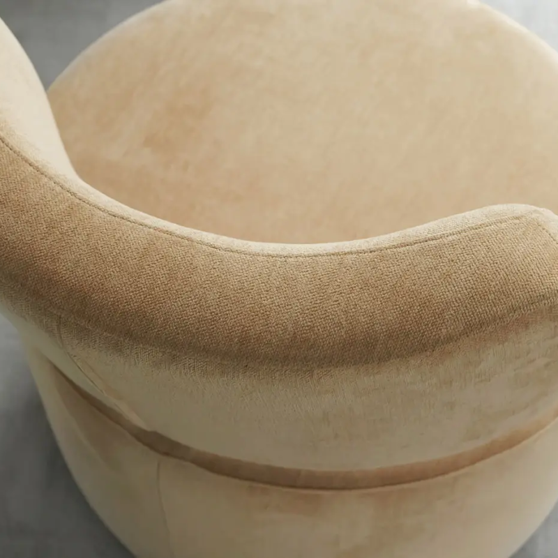 Fauteuil pivotant beige, rond, au dossier incurvé, vu de haut sur un sol gris. Canape Paris by Atelier Bis