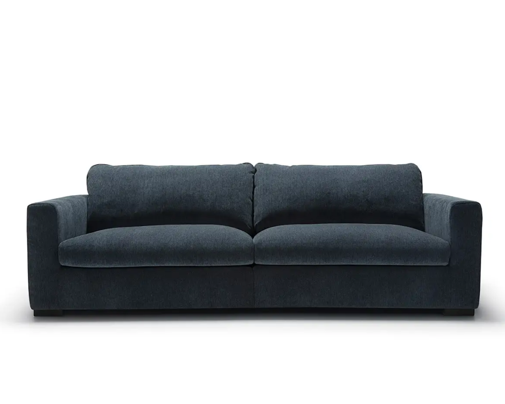 Canapé moderne bleu foncé avec de larges accoudoirs et deux coussins d'assise, sur fond blanc. Canape Paris by Atelier Bis