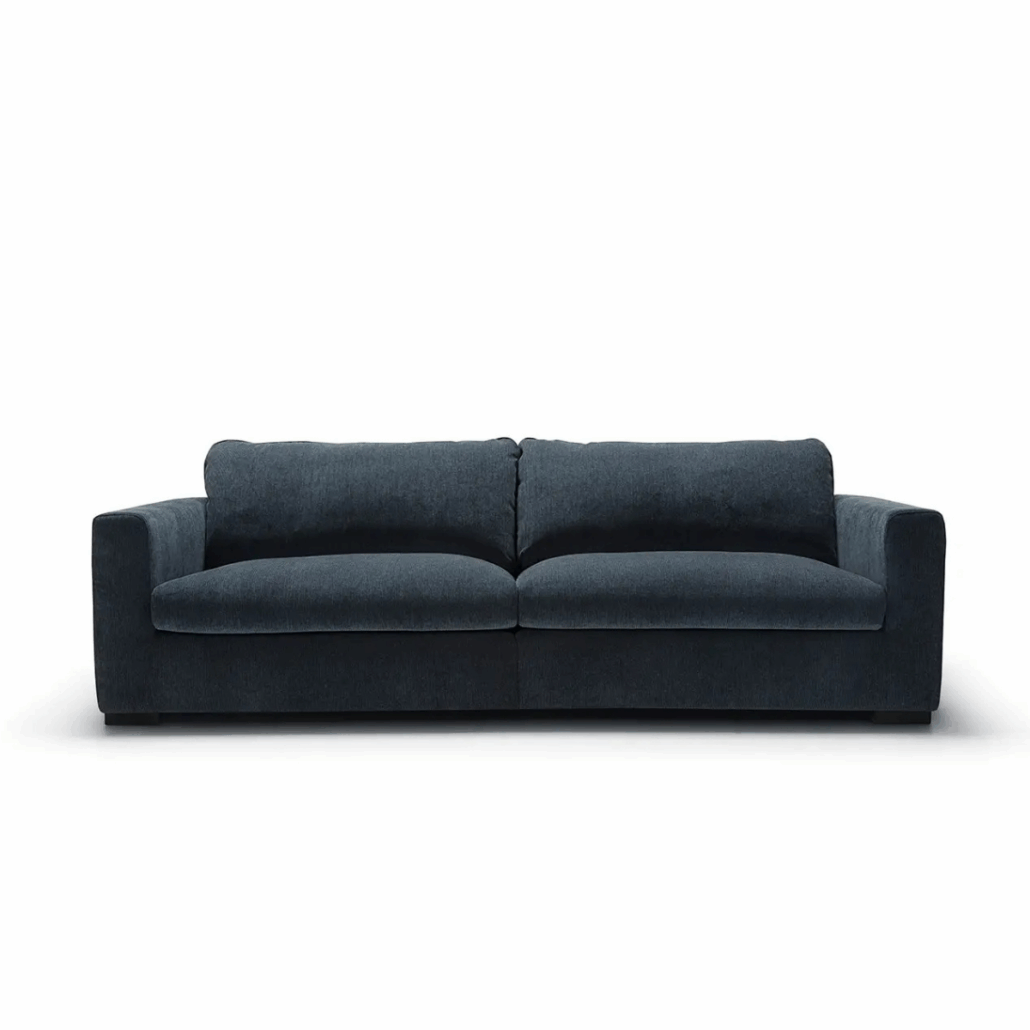 Canapé moderne bleu foncé avec de larges accoudoirs et deux coussins d'assise, sur un fond blanc uni. Canape Paris by Atelier Bis