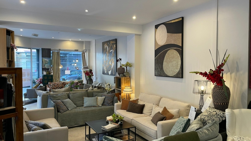 Salon moderne avec plusieurs canapés, des œuvres d'art murales, des lampes et de grandes fenêtres laissant entrer la lumière naturelle. Canape Paris by Atelier Bis