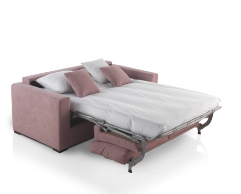 Un canapé rose convertible Homesprit Bidart, allongé dans un lit avec une literie blanche et des oreillers roses, sur fond blanc. Canape Paris by Atelier Bis