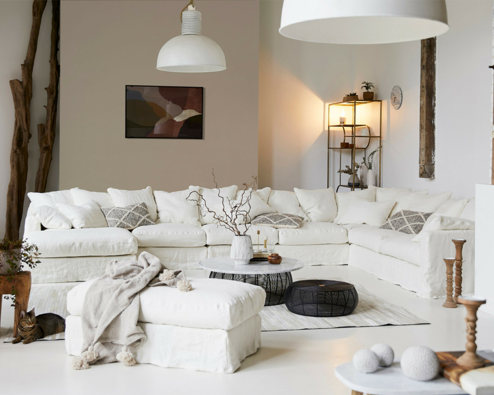 Salon lumineux avec un grand canapé Homesprit Biscarrosse déhoussable, une décoration moderne, des plantes, et un éclairage naturel doux. Canape Paris by Atelier Bis